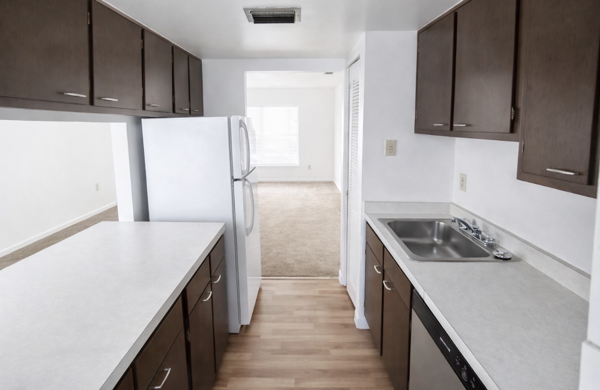 Galley kitchen with dark cabinets and natural light